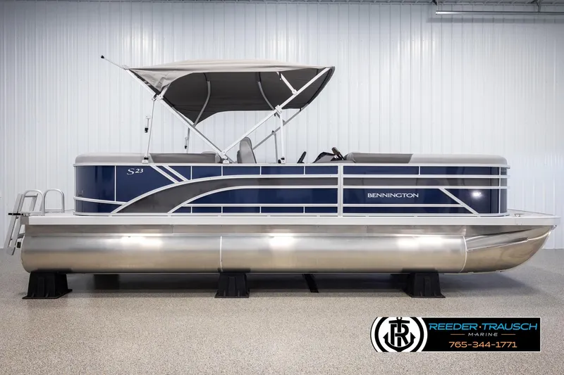 Slide: The Image of 2025 Bennington 23 SSRSE pontoon boat with canopy, displayed indoors at Reeder-Trausch Marine. - 5