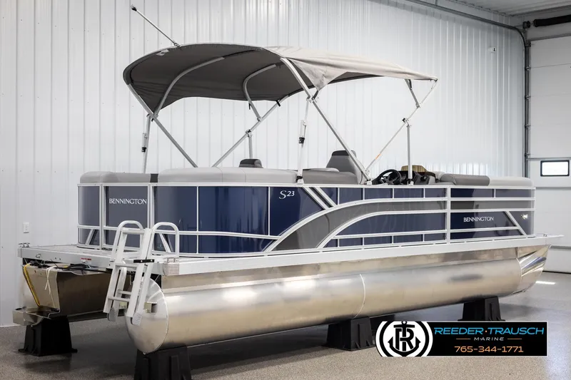 Slide: The Image of 2025 Bennington 23 SSRSE pontoon boat in showroom, featuring sleek design and canopy. - 6
