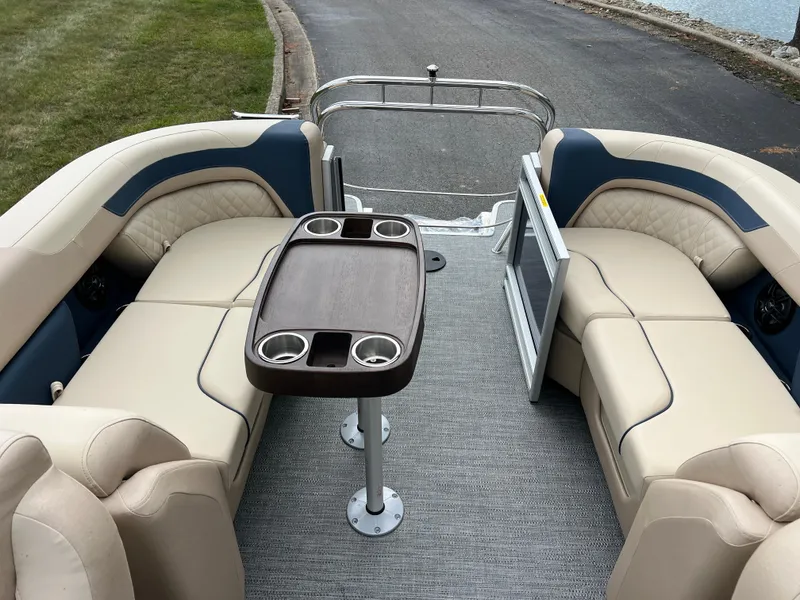 Slide: The Image of 2025 Godfrey SWEETWATER 2286 SB pontoon boat interior with beige seating and central table. - 19