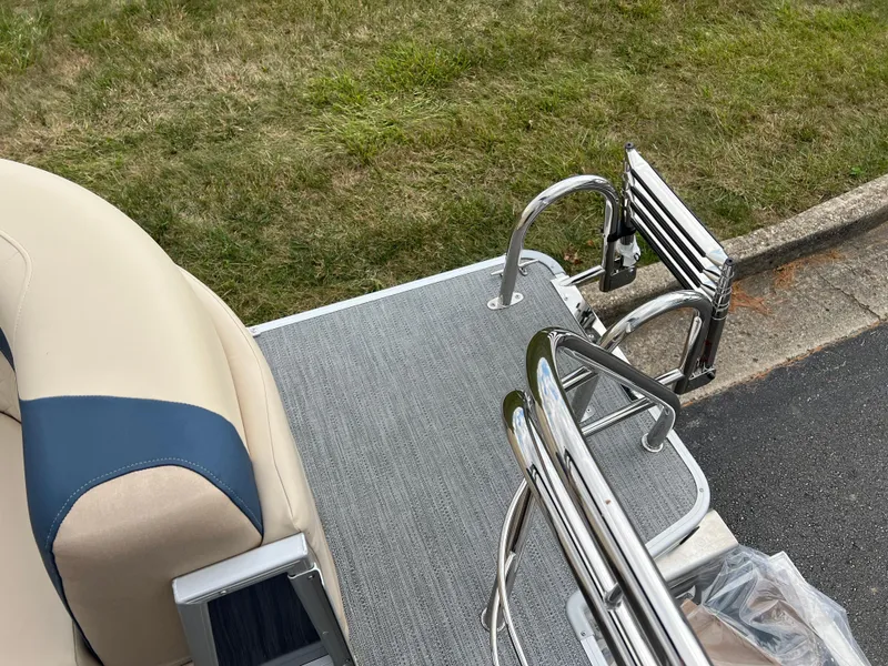 Slide: The Image of 2025 Godfrey SWEETWATER 2286 SB boat deck with ladder and seating, near grass and pavement. - 21