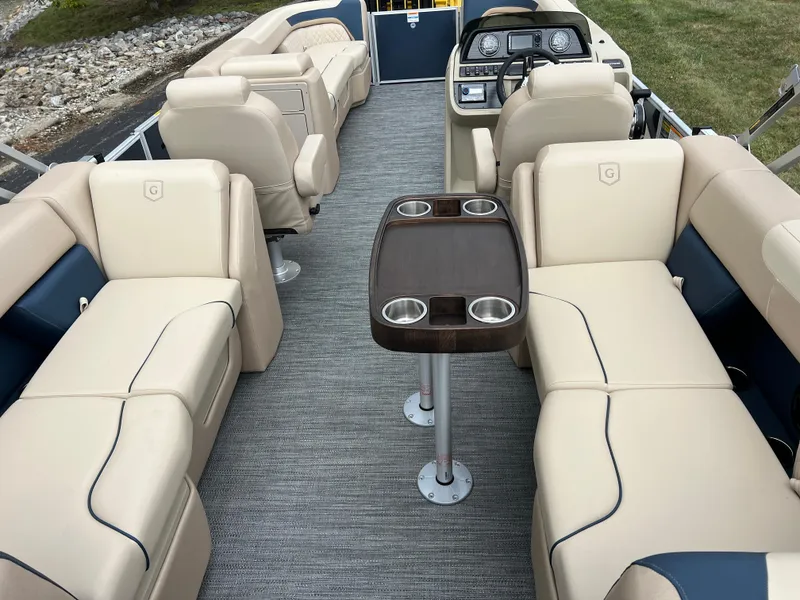 Slide: The Image of 2025 Godfrey SWEETWATER 2286 SB pontoon boat interior with beige seating and central table. - 23