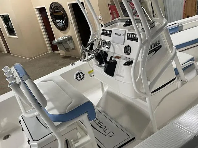 Slide: The Image of 2025 Robalo 206 Cayman boat interior with steering console and seating in showroom. - 5