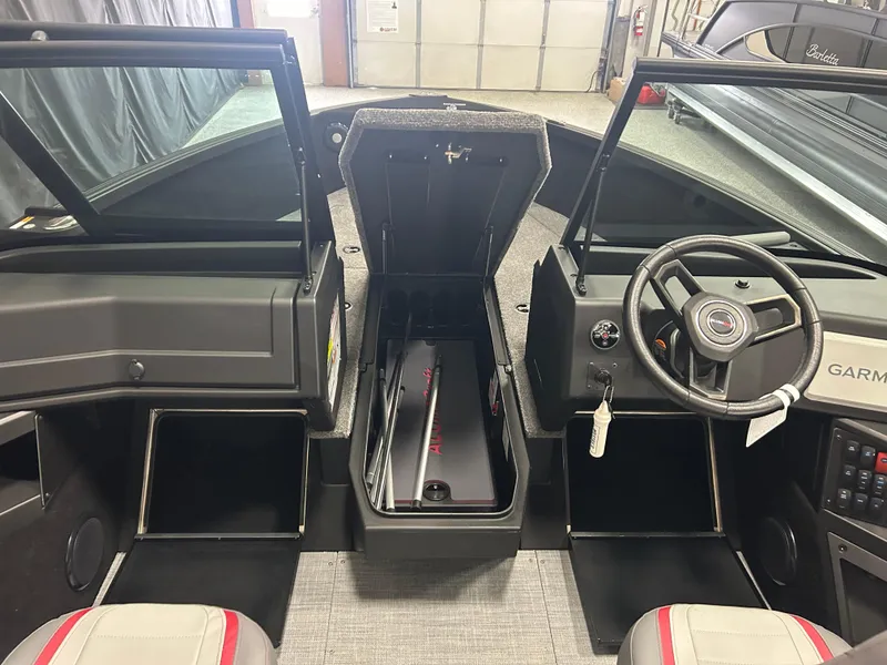 Slide: The Image of 2025 Alumacraft Trophy 185X Sport boat interior with open storage and steering wheel. - 12