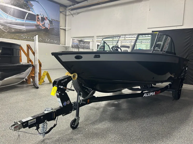 Slide: The Image of 2025 Alumacraft Trophy 185X Sport boat on trailer in showroom. - 2