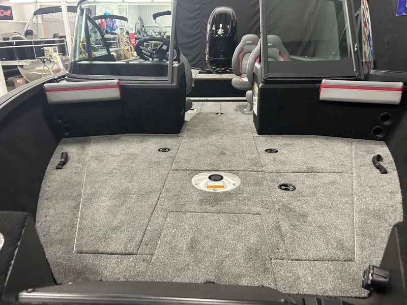 Slide: The Image of 2025 Alumacraft Trophy 185X Sport boat interior with spacious seating and carpeted flooring. - 6