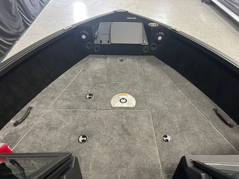 Slide: The Image of 2025 Alumacraft Trophy 185X Sport boat interior with carpeted deck and storage compartments. - 7