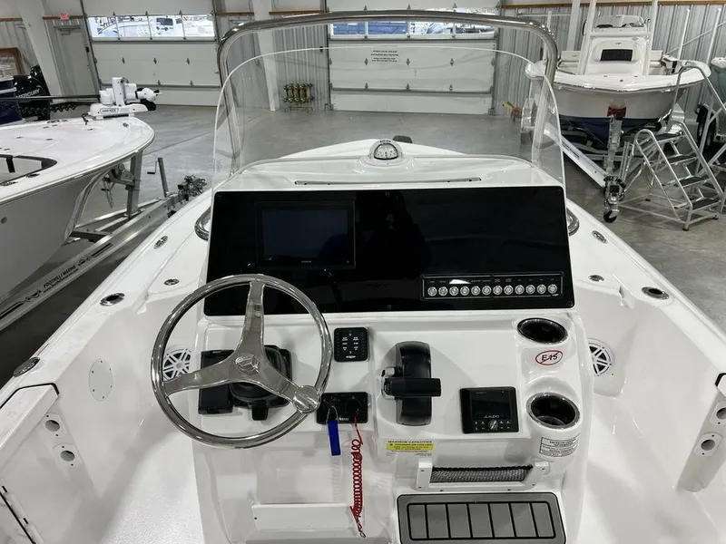 Slide: The Image of 2025 Tidewater 2110 Bay Max boat dashboard with steering wheel and control panel in showroom. - 18
