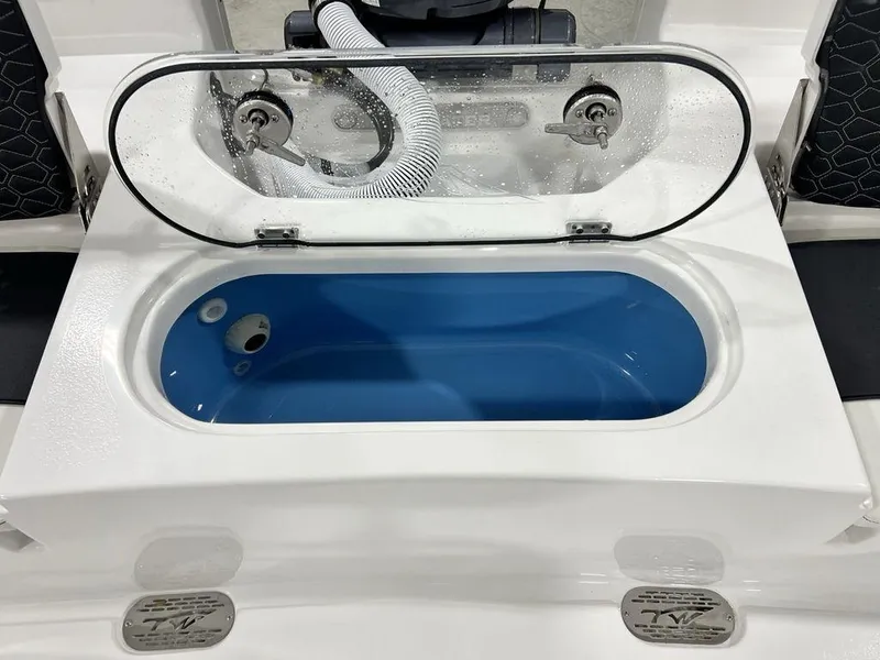 Slide: The Image of 2025 Tidewater 2110 Bay Max boat livewell with open lid and blue interior. - 23