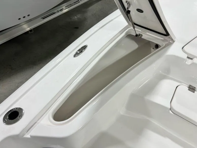 Slide: The Image of 2025 Tidewater 2110 Bay Max boat storage compartment, open lid, white interior. - 7
