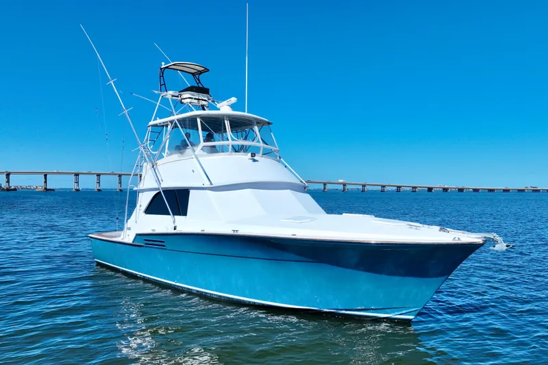 Slide: The Image of 1982 Bertram 46 Convertible yacht on blue water with clear sky background. - 1