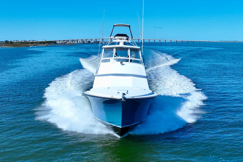 Slide: The Image of 1982 Bertram 46 Convertible yacht cruising on open water, clear blue sky. - 14