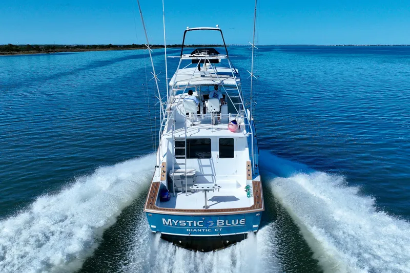 Slide: The Image of 1982 Bertram 46 Convertible yacht cruising on open water, rear view. - 18