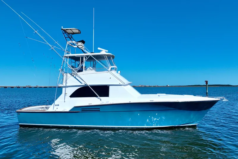 Slide: The Image of 1982 Bertram 46 Convertible yacht on calm blue water. - 2