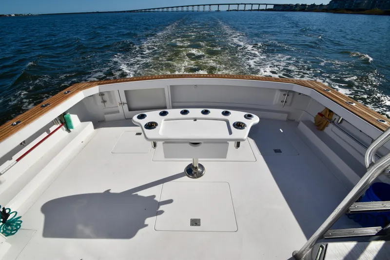 Slide: The Image of 1982 Bertram 46 Convertible boat deck with ocean view and fishing setup. - 21