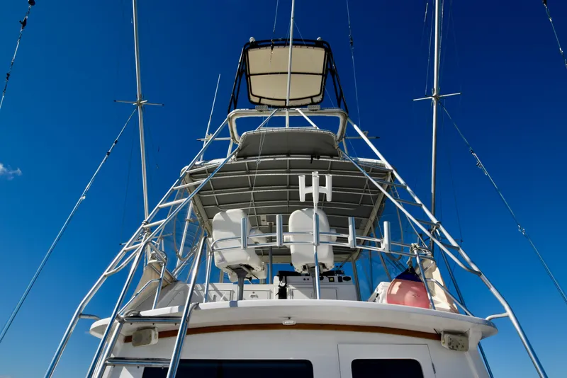 Slide: The Image of 1982 Bertram 46 Convertible yacht with tower against clear blue sky. - 23