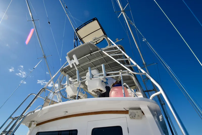 Slide: The Image of 1982 Bertram 46 Convertible yacht, view of upper deck and rigging against clear blue sky. - 28