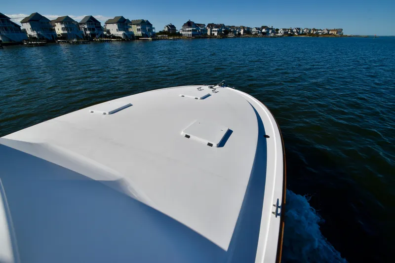 Slide: The Image of 1982 Bertram 46 Convertible cruising near waterfront homes. - 29