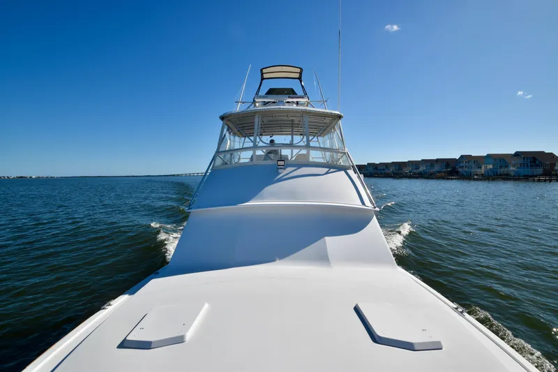 Slide: The Image of 1982 Bertram 46 Convertible yacht cruising on open water under clear blue sky. - 31