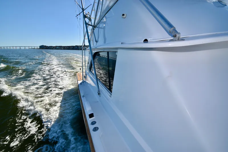 Slide: The Image of 1982 Bertram 46 Convertible cruising on open water, leaving a wake behind. - 33