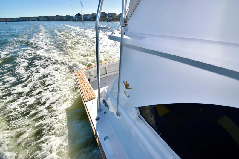 Slide: The Image of 1982 Bertram 46 Convertible cruising on open water, leaving a wake behind. - 34