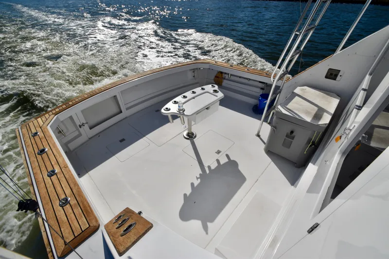 Slide: The Image of 1982 Bertram 46 Convertible boat deck with fishing setup on open water. - 35