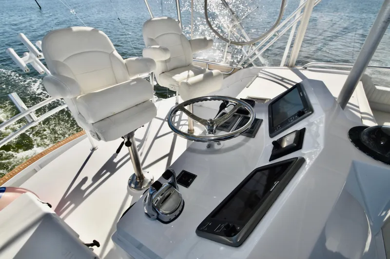 Slide: The Image of 1982 Bertram 46 Convertible helm with white captain chairs and modern navigation equipment. - 44