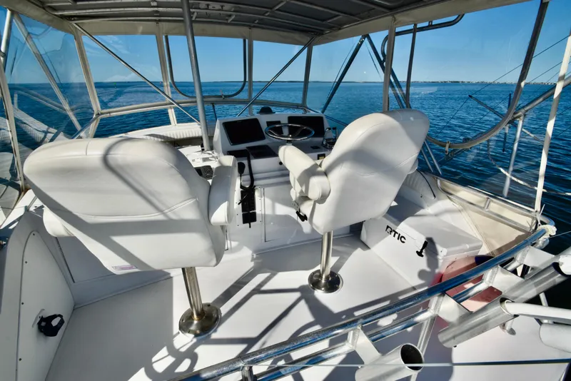 Slide: The Image of Interior of 1982 Bertram 46 Convertible yacht with white seating and ocean view. - 48