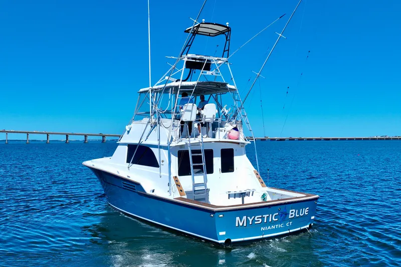 Slide: The Image of 1982 Bertram 46 Convertible boat "Mystic Blue" on open water, clear sky background. - 5