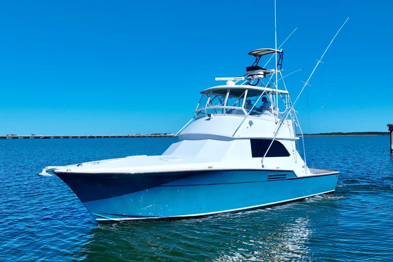 Slide: The Image of 1982 Bertram 46 Convertible yacht cruising on clear blue water. - 7