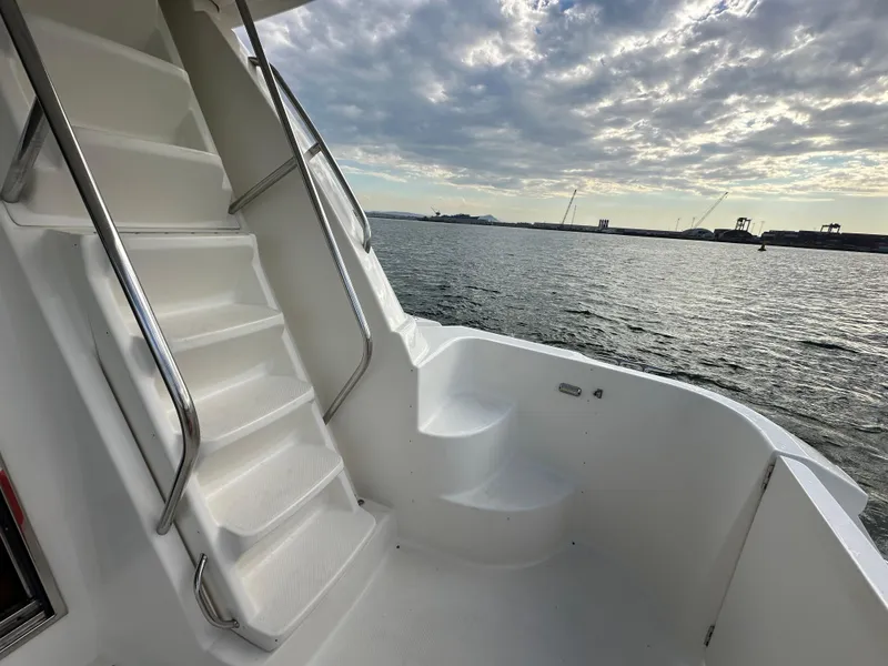 Slide: The Image of Meridian 580 Pilothouse 2004 yacht deck with stairs, overlooking serene ocean view. - 24