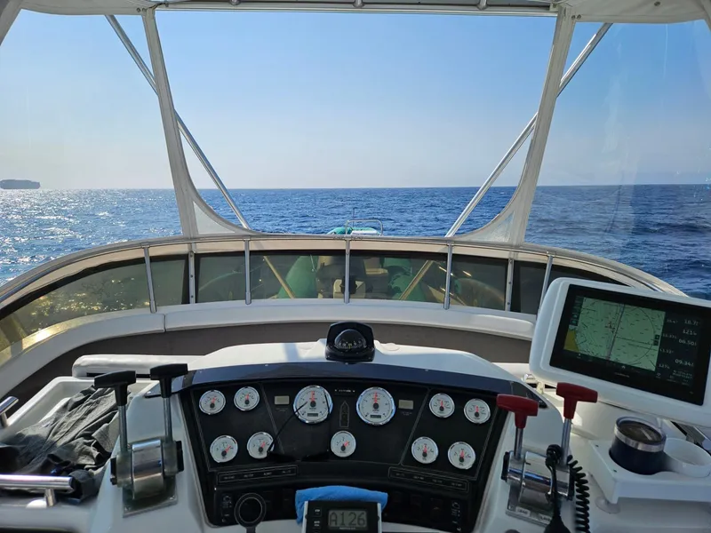 Slide: The Image of 1988 Trojan 12 Meter Convertible yacht interior with white seating and waterfront view. - 19