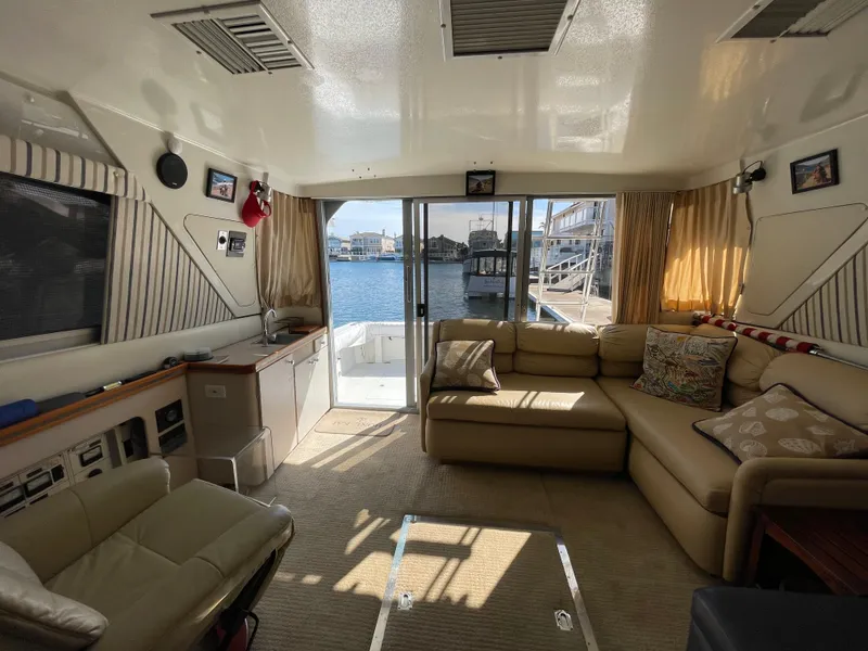 Slide: The Image of 1988 Trojan 12 Meter Convertible yacht docked, featuring a sleek deck and mooring equipment. - 37