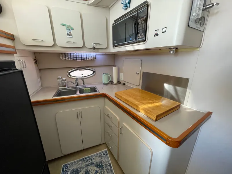 Slide: The Image of 1988 Trojan 12 Meter Convertible yacht interior with kitchenette and ocean view. - 42