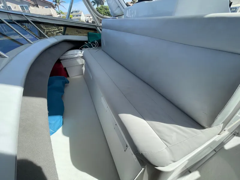 Slide: The Image of 1988 Trojan 12 Meter Convertible boat with covered seats, docked by waterfront homes. - 21