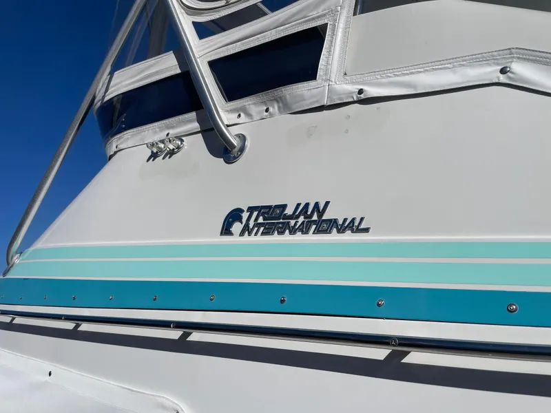 Slide: The Image of 1988 Trojan 12 Meter Convertible boat interior with cushioned seating and control panel. - 26