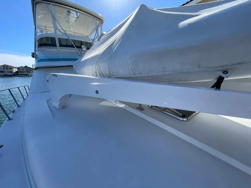 Slide: The Image of 1988 Trojan 12 Meter Convertible boat with blue and teal accents under clear sky. - 30