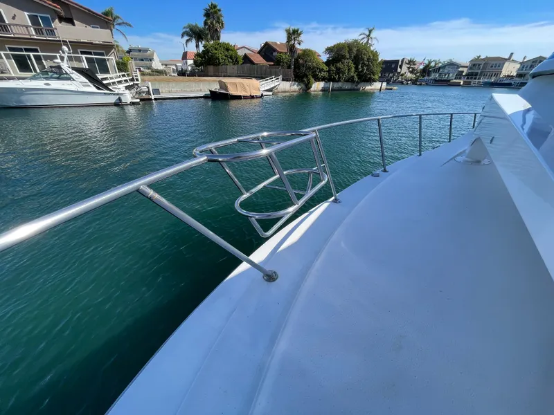 Slide: The Image of 1988 Trojan 12 Meter Convertible yacht with turquoise sunbathing deck, anchored in clear blue waters. - 32