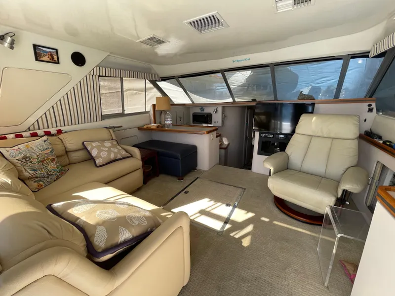 Slide: The Image of 1988 Trojan 12 Meter Convertible yacht with covered deck, docked in sunny marina. - 34