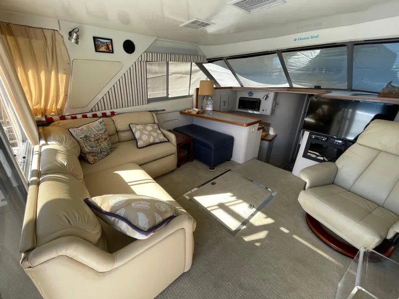 Slide: The Image of 1988 Trojan 12 Meter Convertible boat docked, featuring teal seating and steering wheel. - 35