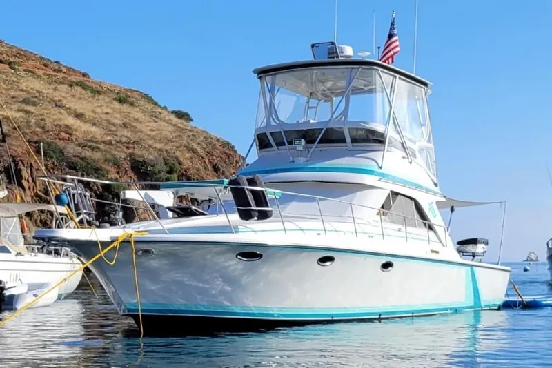 Slide: The Image of 1988 Trojan 12 Meter Convertible yacht docked at marina under clear blue sky. - 4