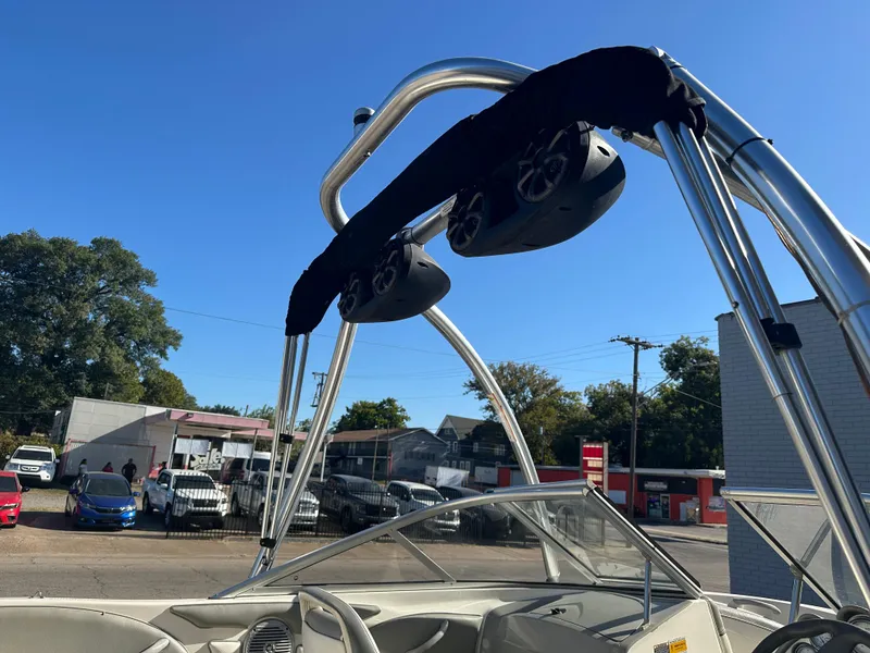 Slide: The Image of 2011 Bayliner 185 boat with wakeboard tower and speakers, parked outdoors. - 20