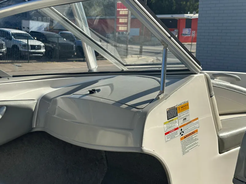 Slide: The Image of Interior view of 2011 Bayliner 185 boat, showcasing dashboard and safety labels. - 22