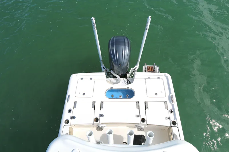 Slide: The Image of 2021 Tidewater 2500 Carolina Bay boat stern view with motor on green water. - 14