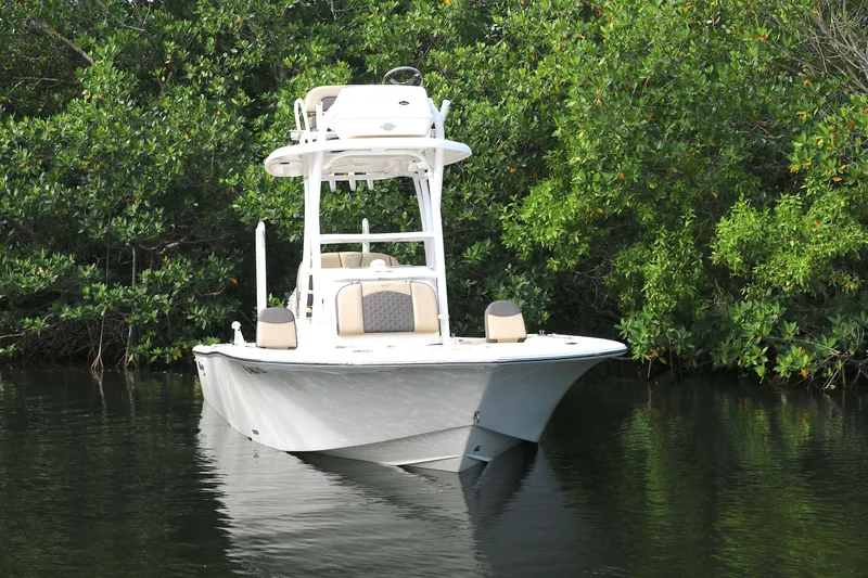 Slide: The Image of 2021 Tidewater 2500 Carolina Bay boat on calm water, surrounded by lush greenery. - 15