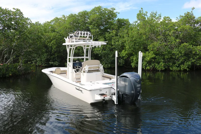 Slide: The Image of 2021 Tidewater 2500 Carolina Bay boat on calm water, surrounded by lush greenery. - 16
