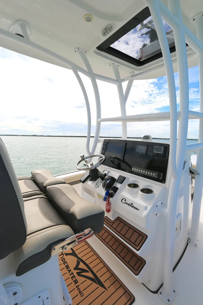 Slide: The Image of 2021 Tidewater 2500 Carolina Bay boat interior with helm and seating. - 2