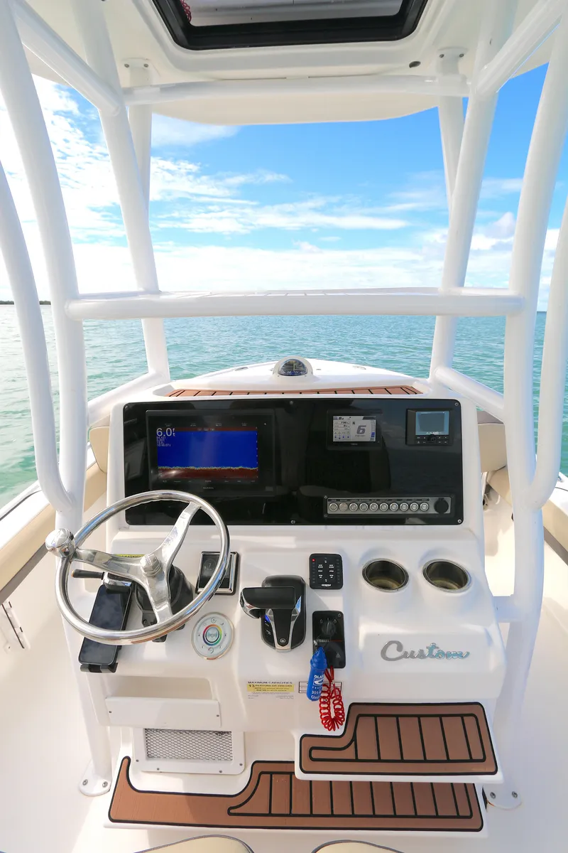 Slide: The Image of 2021 Tidewater 2500 Carolina Bay boat console with steering wheel and navigation system. - 3