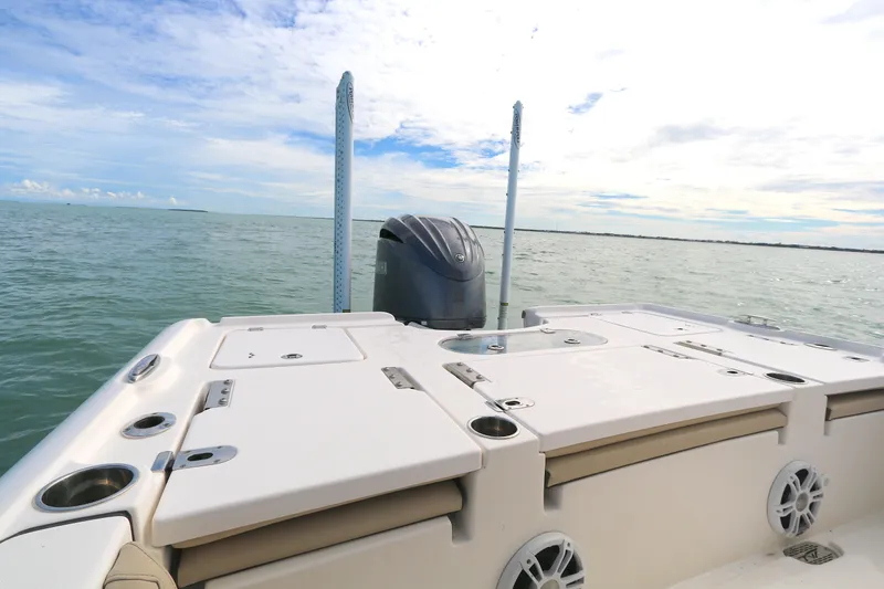 Slide: The Image of 2021 Tidewater 2500 Carolina Bay boat on calm water, showcasing rear deck and motor. - 8