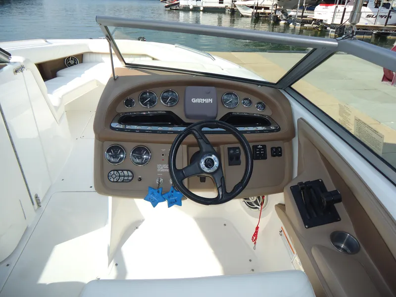 Slide: The Image of 2007 Cobalt 302 boat dashboard with steering wheel and gauges, docked by the water. - 15