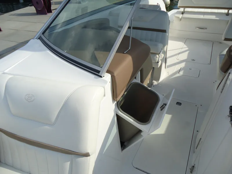 Slide: The Image of 2007 Cobalt 302 boat interior with white seating and open storage compartment. - 23